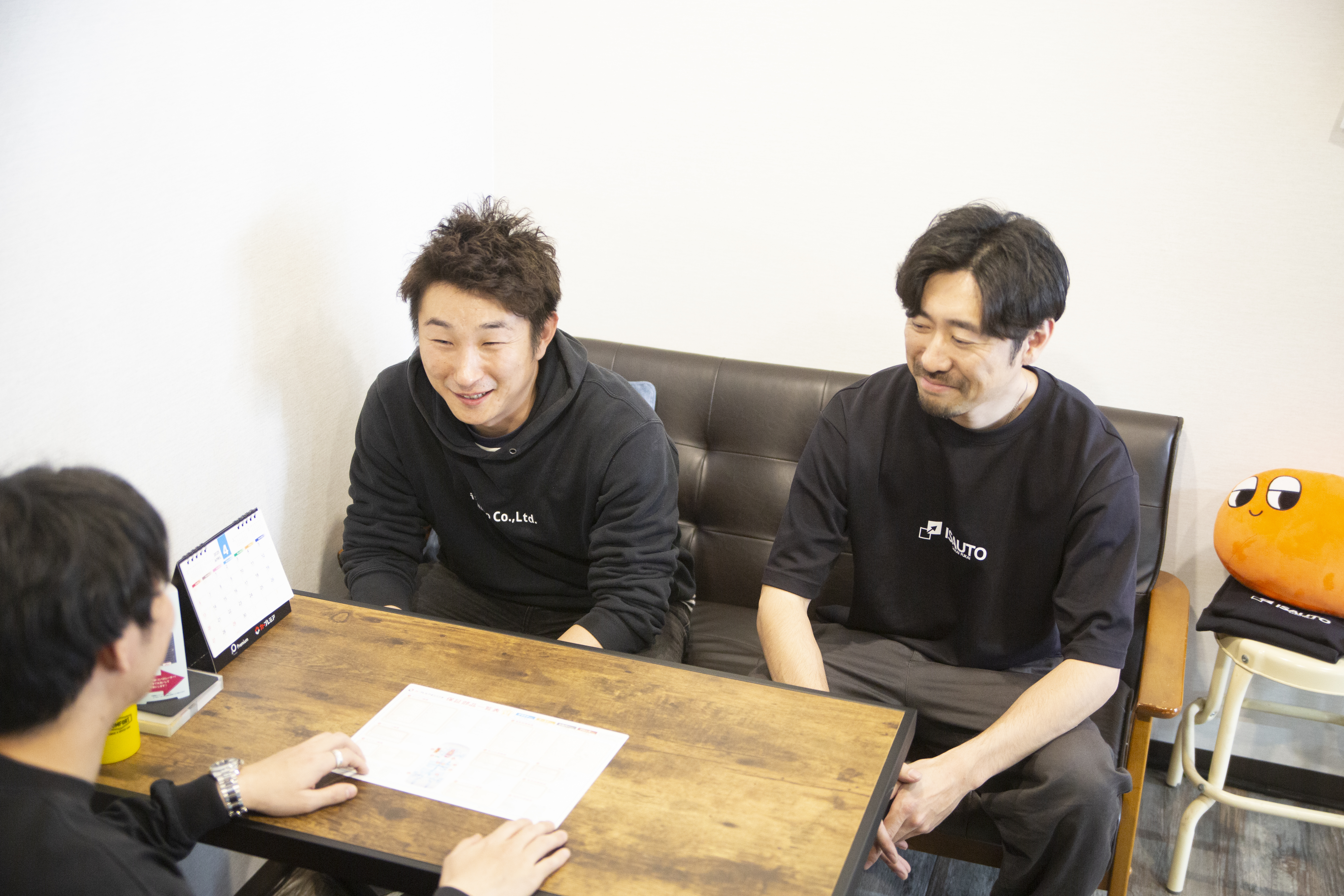 デスクでミーティングする男性３人